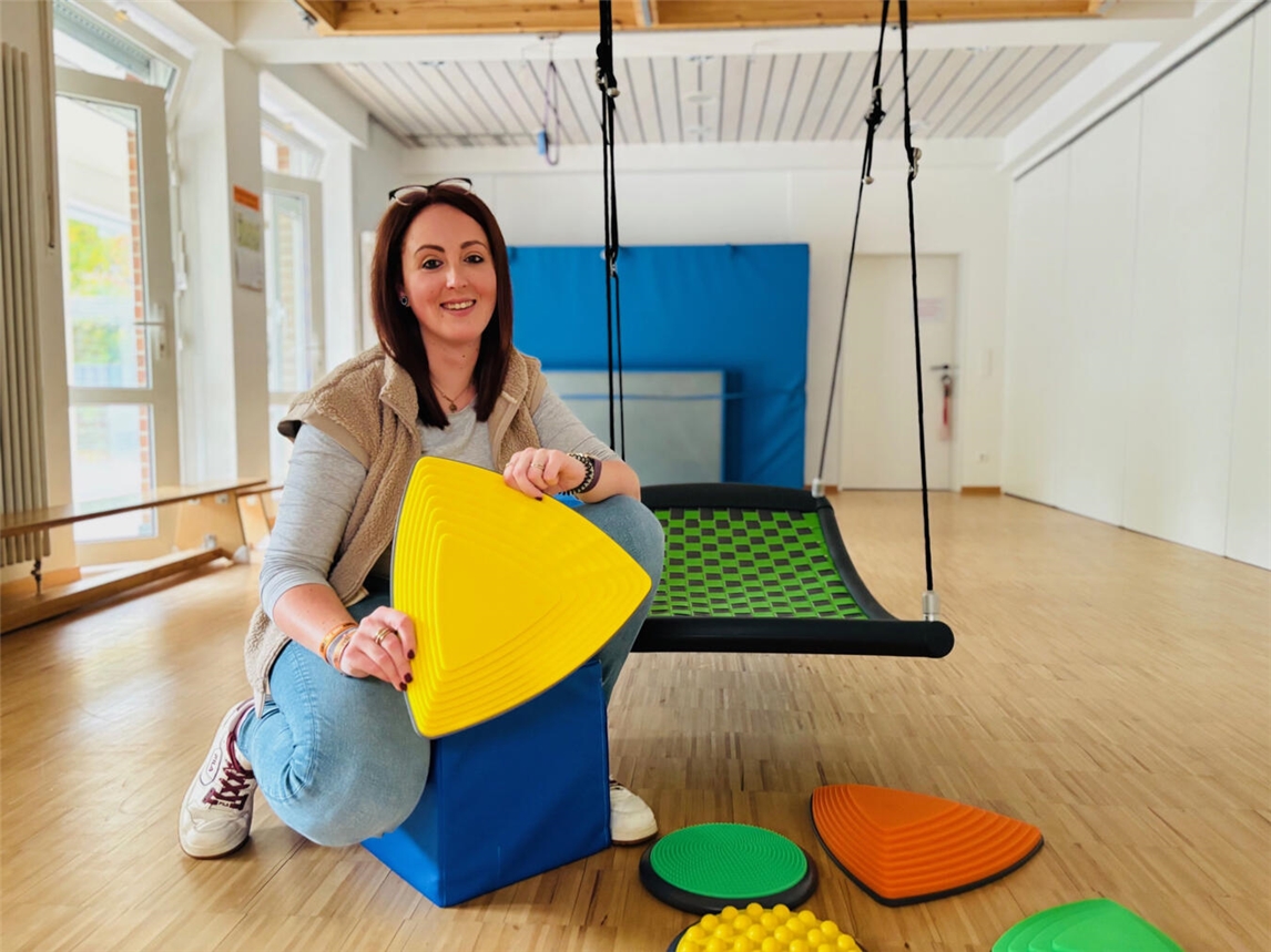 Jung, engagiert, ganzheitlich Kita-Leiterin Jannine van Dülmen mit den neuen Flusssteinen in der Turnhalle des Familienzentrums Zauberstern in Kleve. Foto: Caritas