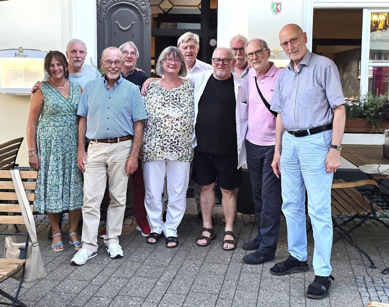 "Klassentreffen in Kempen, Gruppe von ehemaligen Schülern lächelnd in Park"