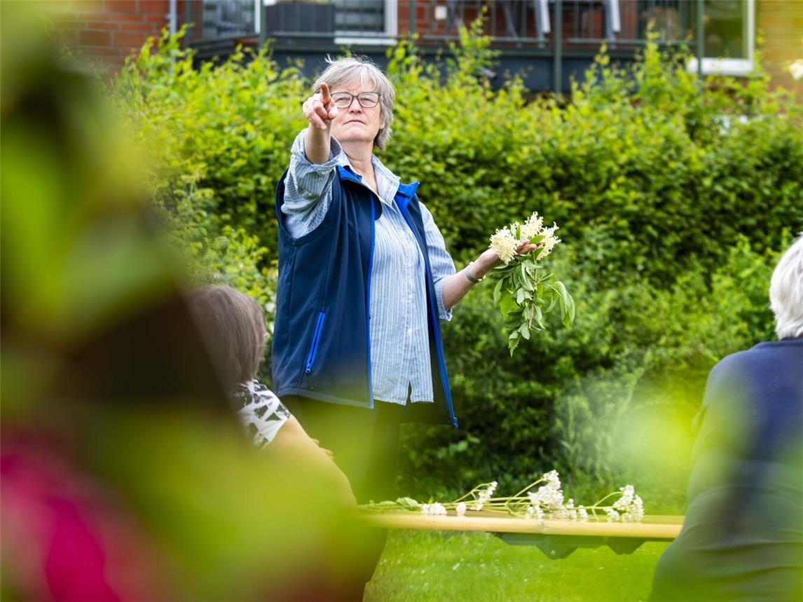 Kräuterexpertin Ute Stehlmann zeigt den Teilnehmern duftende Frühlingskräuter. Foto: Gerhard Seybert