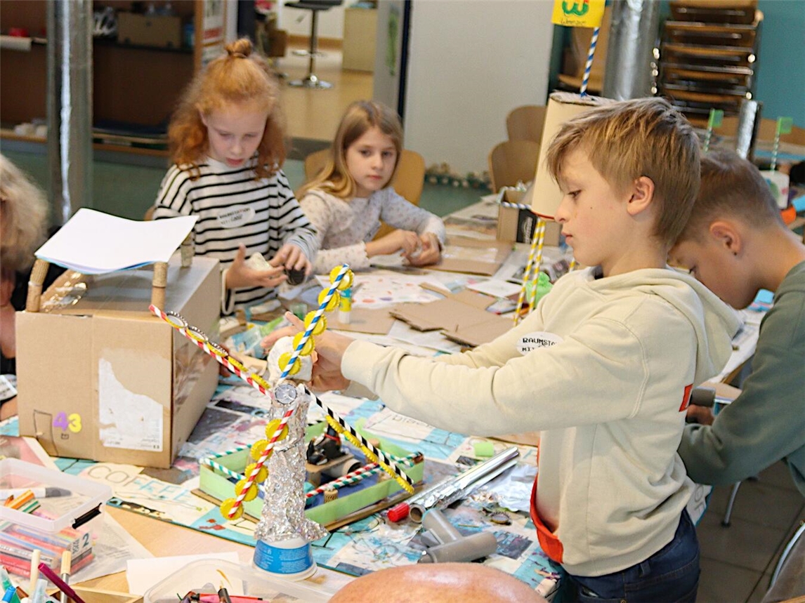Kreative Ideen für den „Stadtplan aus Kinderperspektive“: Dagmar Nieke (2.v.l.) von „Diskurs Niederrhein“ arbeitet mit den Kindern im Weezer Wellenbrecher die Ideen für die Modelle aus. Foto: Kreis Kleve