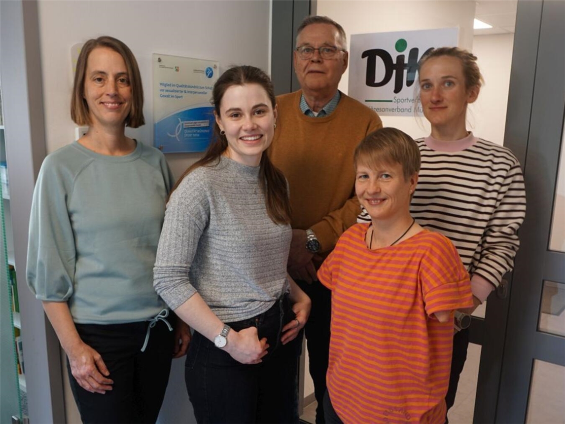 DJK Münster freut sich über Aufnahme ins PSIG-Qualitätsbündnis; Gruppenfoto mit Plakette in Geschäftsstelle, Personen lächelnd.