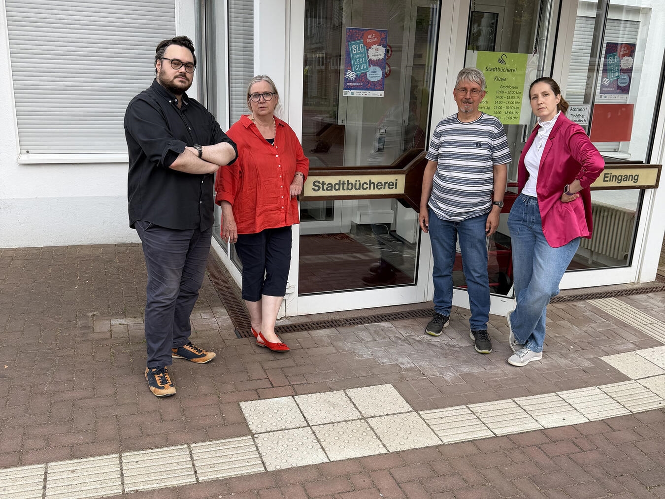 Vier Personen protestieren gegen Haushaltskürzungen der Stadtbücherei. Von links: Daniel Boumanns, Petra Tekath, Michael Meuten, Yvonne Lamik.