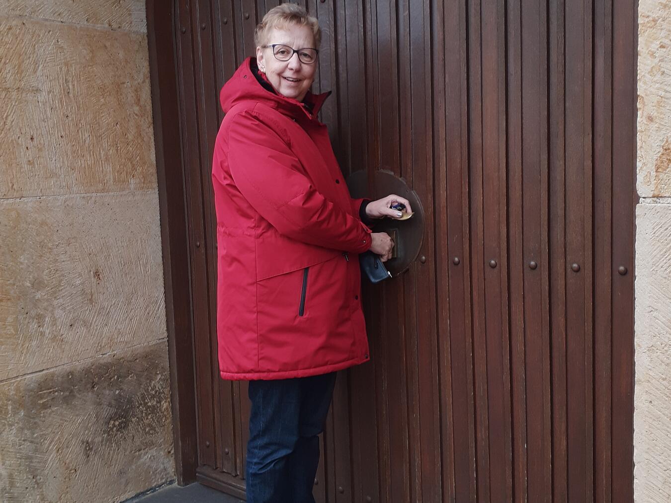 Küsterin Annegret Neumann schließt die Kirchentür am Ende ihrer Dienstzeit. Foto: Georg Dahlhaus