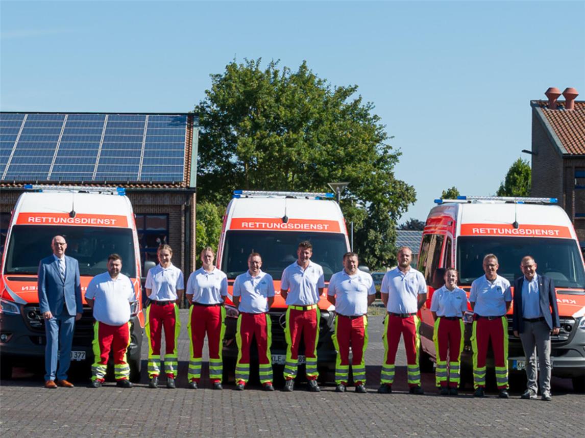 Landrat Christoph Gerwers (l.) und der zuständige Fachbereichsleiter und Betriebsleiter des Rettungsdienstes des Kreises Kleve, Jürgen Baetzen (r.), mit Rettungsdienstpersonal und den acht neuen Krankentransportwagen am Kreisfeuerwehrgerätehaus in Goch. Foto: Kreis Kleve