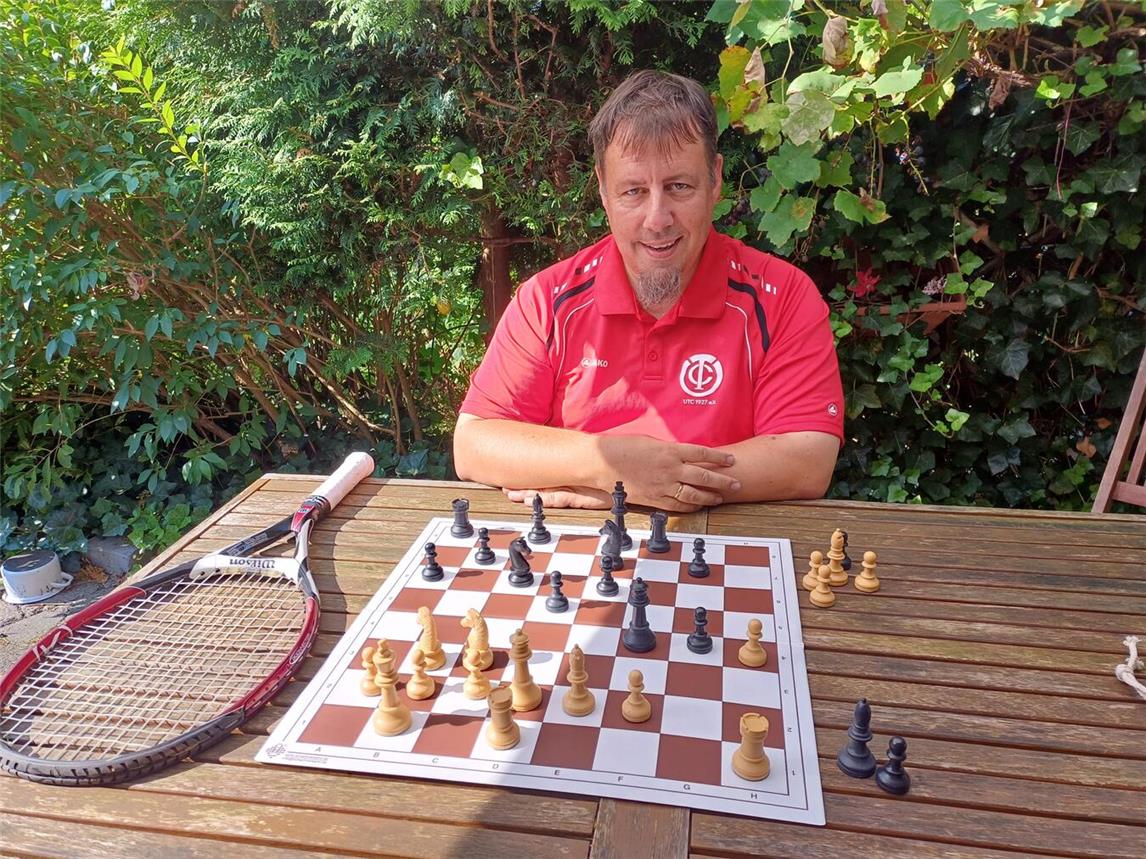 Lars Günther im Tennis-Trikot am Schachbrett bei der Vorbereitung zum Turnier. Foto: privat