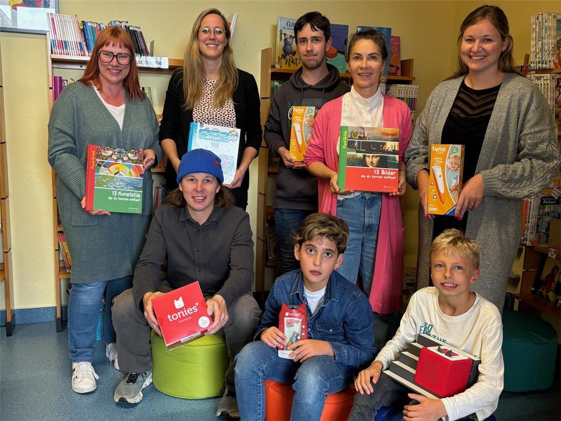 Lesebegeisterte Schüler, das Team der Bönninghardt-Schule und die Überbringer von Context freuen sich über die Bücherspende. Foto: Context e.V.
