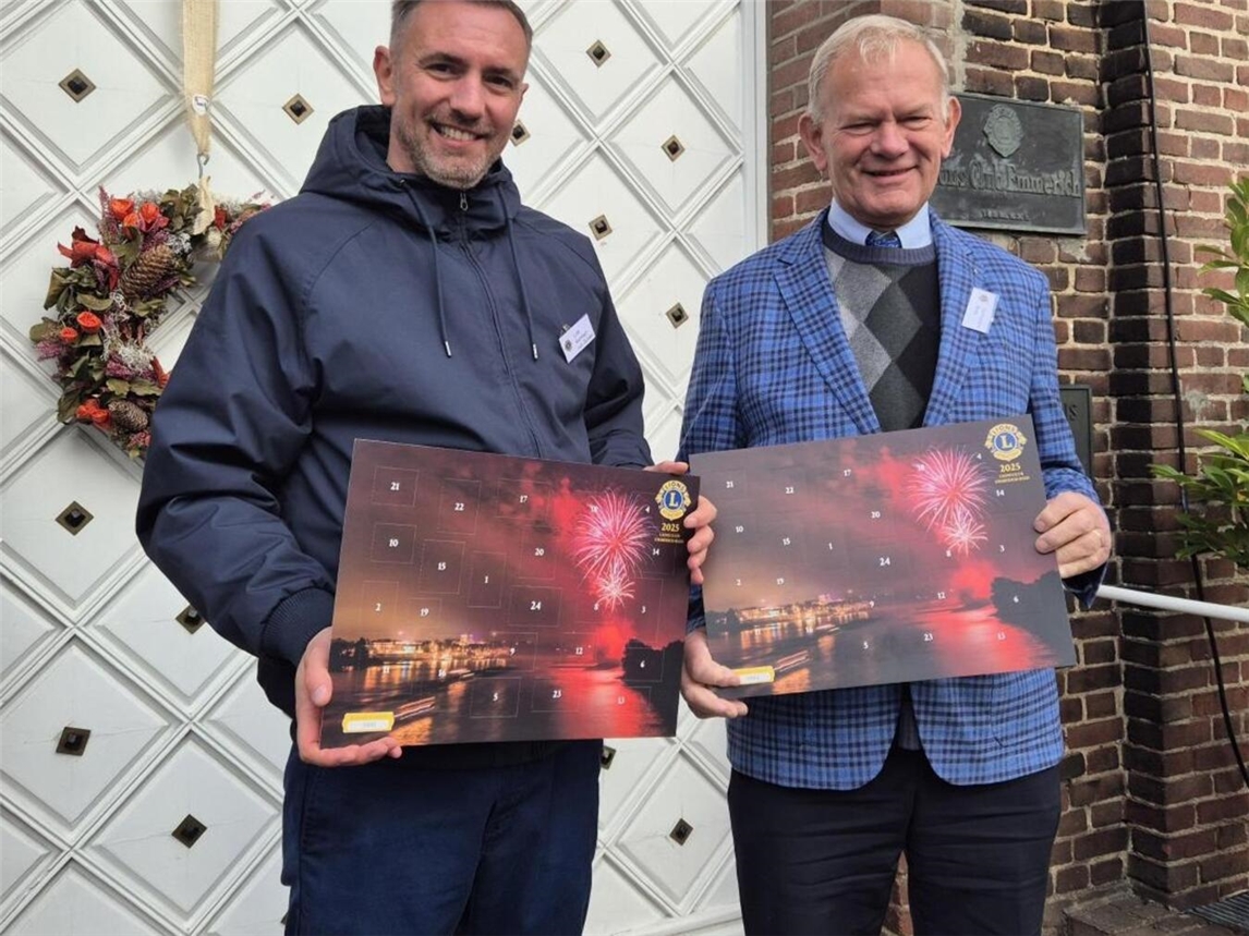Lions-Präsident Lutz Reinhart-van Gülpen und Gerhardus Brus (v. l.) vom Adventskalender-Team des Lions-Club Emmerich-Rees mit dem aktuellen Adventskalender. Foto: privat