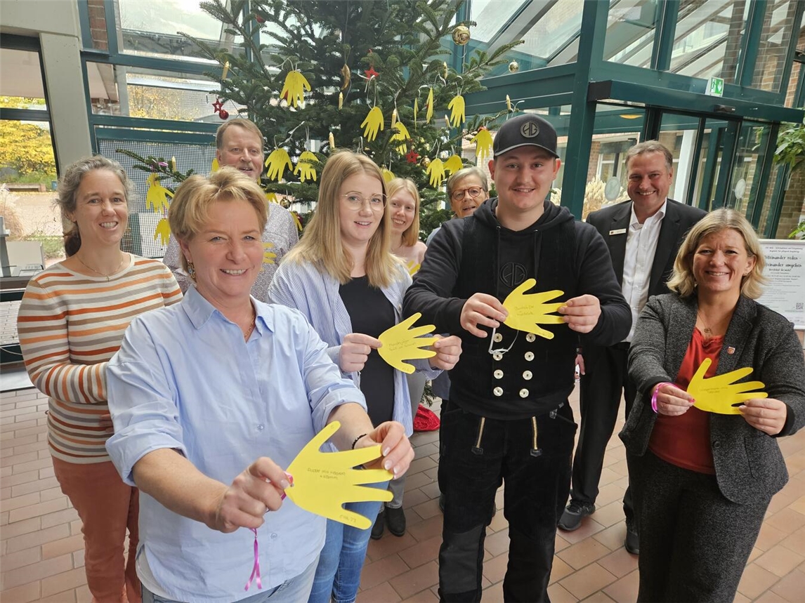 Machen sich für Kinder stark (v.l.): Mila Siebers, Katja Ververs, Jörg Giesen (der seit vielen Jahren die Aktion unterstützt und die prächtige Tanne stiftet), Fabienne Odendahl, Jessica Aengenheister, Agnes Quinders, Maurice Odendahl, Ludger Wehren und Nadine Bogedain. NN-Foto: vs