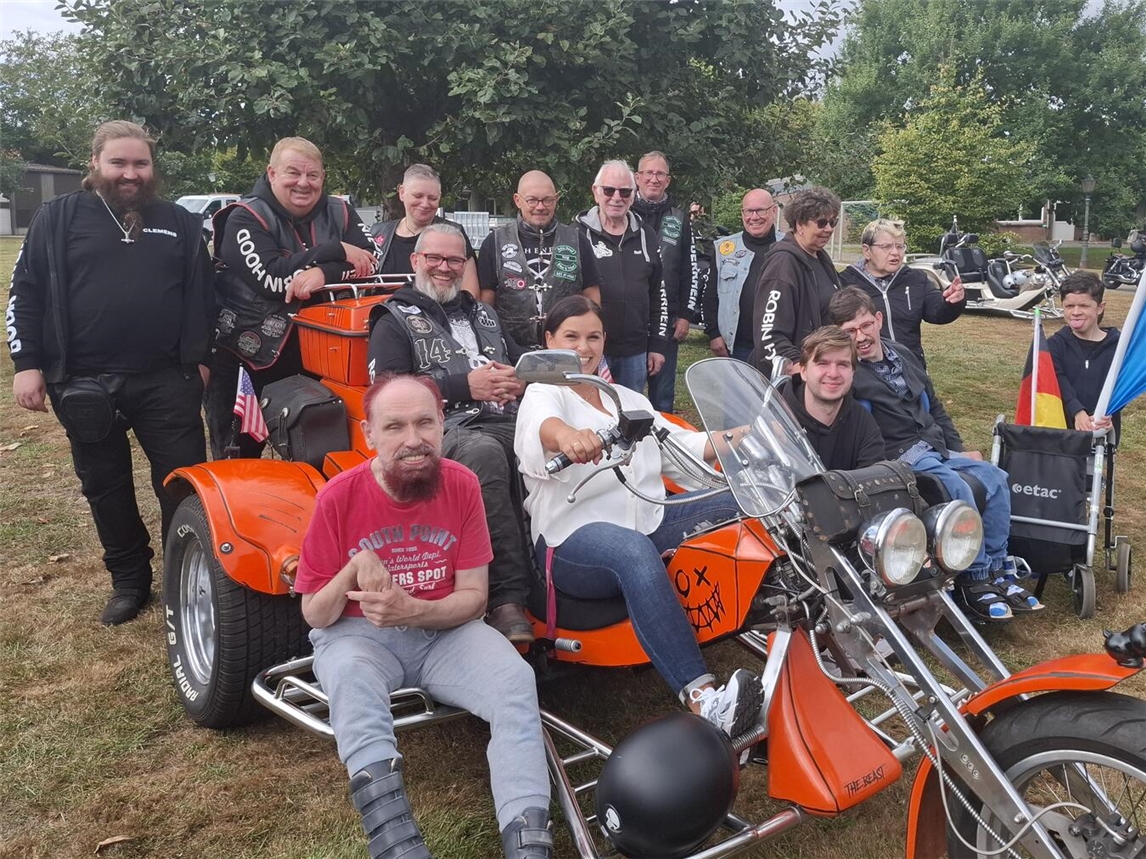 Magdalena Chrobok-Kowalska und Thorsten Strohschän auf einem Trike – umgeben von Bewohnern des Wohnheims Groin und den „Robin Hood Bikern & Trikern“. Foto: LHUN