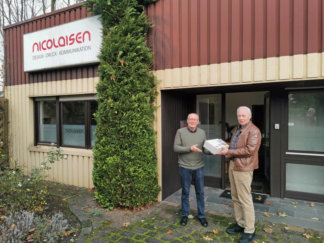 Flyers der Fairtrade-Stadt Geldern aktualisiert Manfred Austrup (l.), Mitglied der Steuerungsgruppe, nahm die 500 Exemplare von Firmeninhaber Svend Nicolaisen dankend entgegen. Foto: privat
