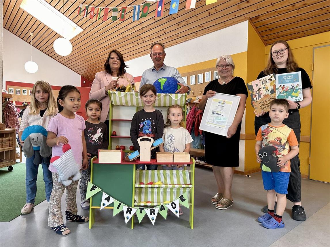 Markus Grönheim (Beigeordneter Stadt Geldern) und Gaby Voss (hinten links, Team Kita Stadt Geldern) freuen sich mit den Kindern und dem Team der Kita Drachenhöhle um Leiterin Anja Schwack (2.v.r.) und Katja Grimm (r.) über die Auszeichnung als „Faire Kita“.Foto: Stadt Geldern/Terhorst
