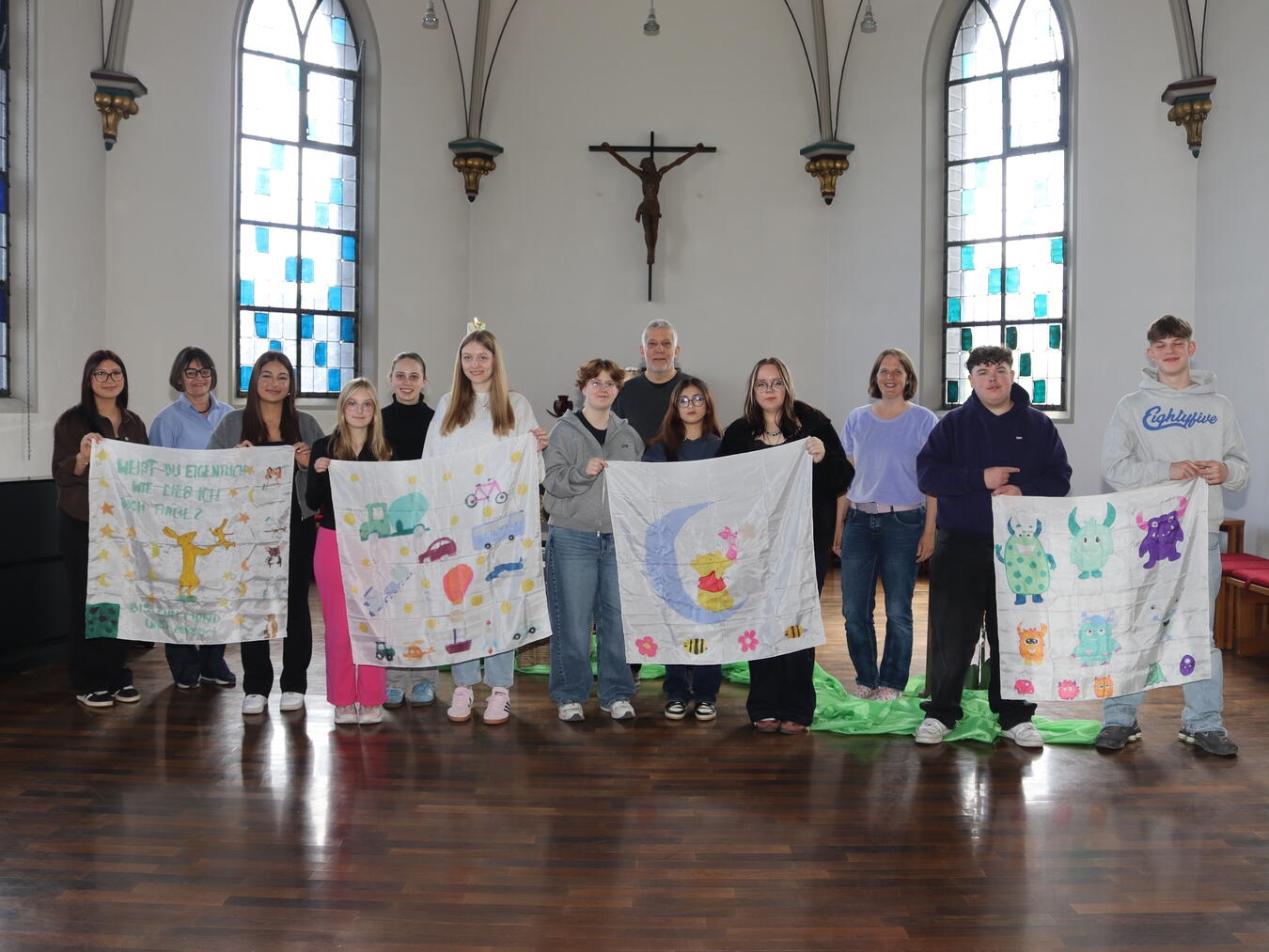 "Martin Naton und Katharina van Meegeren erhalten Seidentücher, gestaltet von Fachabiturienten unter Leitung von Birgit Veltjens-Nühlen."