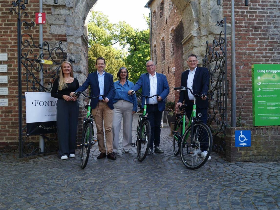 Martina Baumgärtner (m.) und Kathrin Peters von NT freuen sich über die positive Resonanz nach der Umrüstung der NiederrheinRäder. Zum Ortstermin an der Burg Brüggen kamen Dr. Martin Plum (l.), Udo Schiefner (2.v.r.) sowie der Brüggener Wirtschaftsförderer Guido Schmidt. Foto: NT