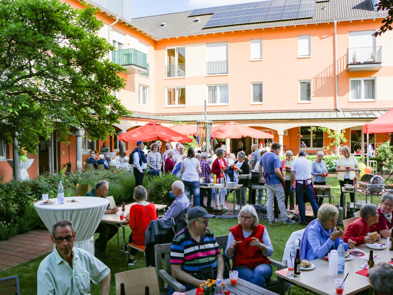 "Versammlung von Freiwilligen im Klostergarten Kevelaer, organisiert von Caritas, zur Würdigung ehrenamtlichen Engagements"