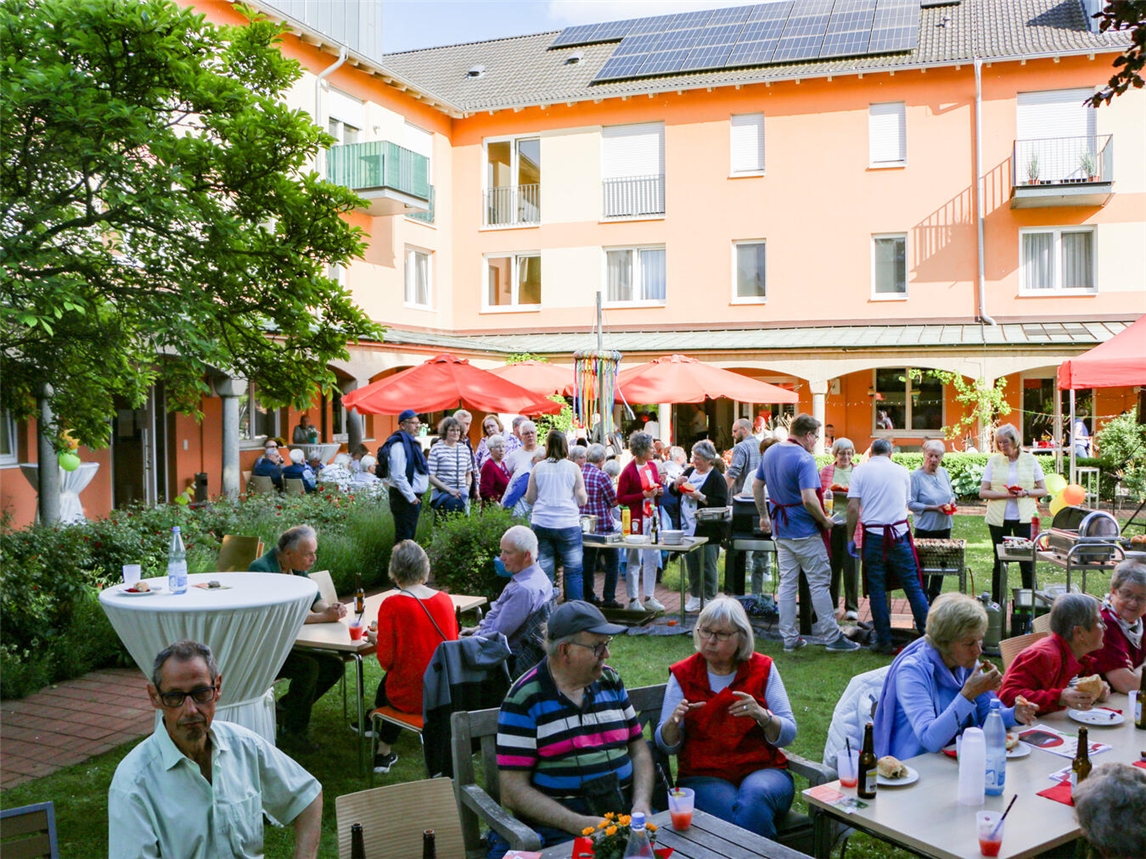 "Versammlung von Freiwilligen im Klostergarten Kevelaer, organisiert von Caritas, zur Würdigung ehrenamtlichen Engagements"