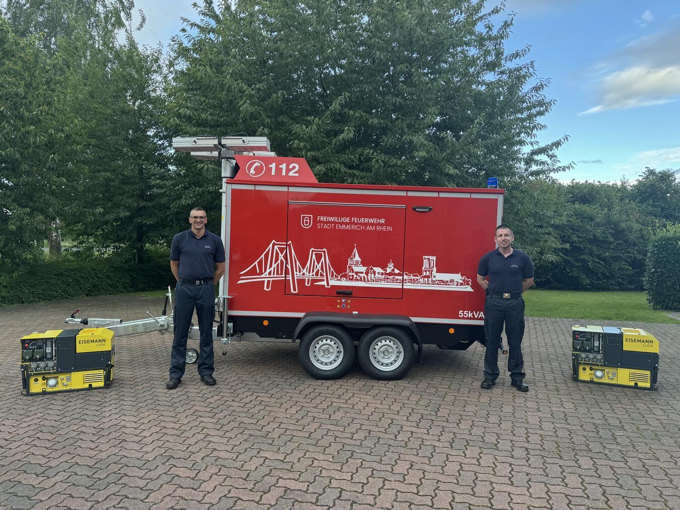 Michael Basten und Christian Knorr von der Emmericher Feuerwehr (v. l.) mit dem mobilen sowie zwei tragbaren Stromerzeugern. Foto: Stadt Emmerich