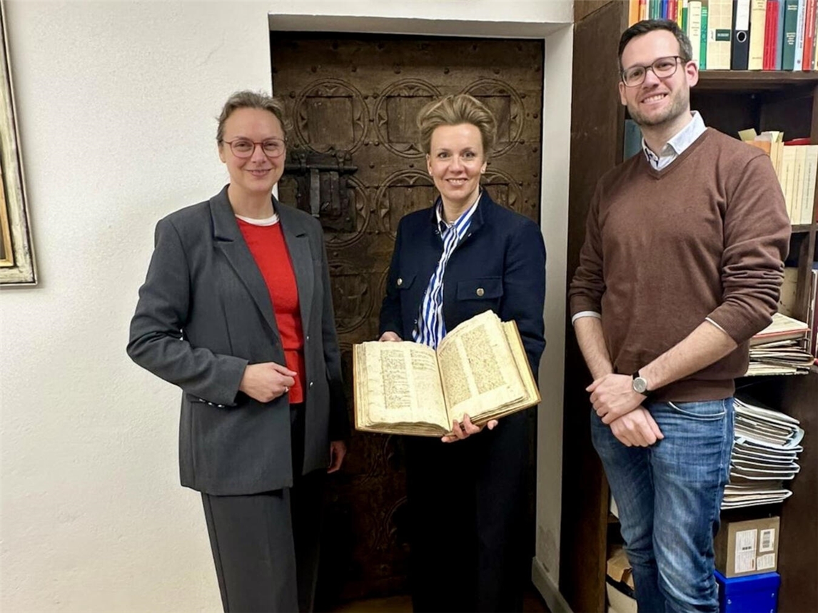 Ministerin Ina Brandes (mit Sachsenspiegel) neben Bürgermeisterin Alexandra Schacky und Stadtarchivar Mathis Ingenhaag. Foto: MKW NRW