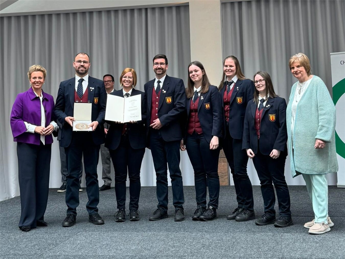 Ministerin Ina Brandes überreicht Plakette und Urkunde an MV Lyra-Abordnung.