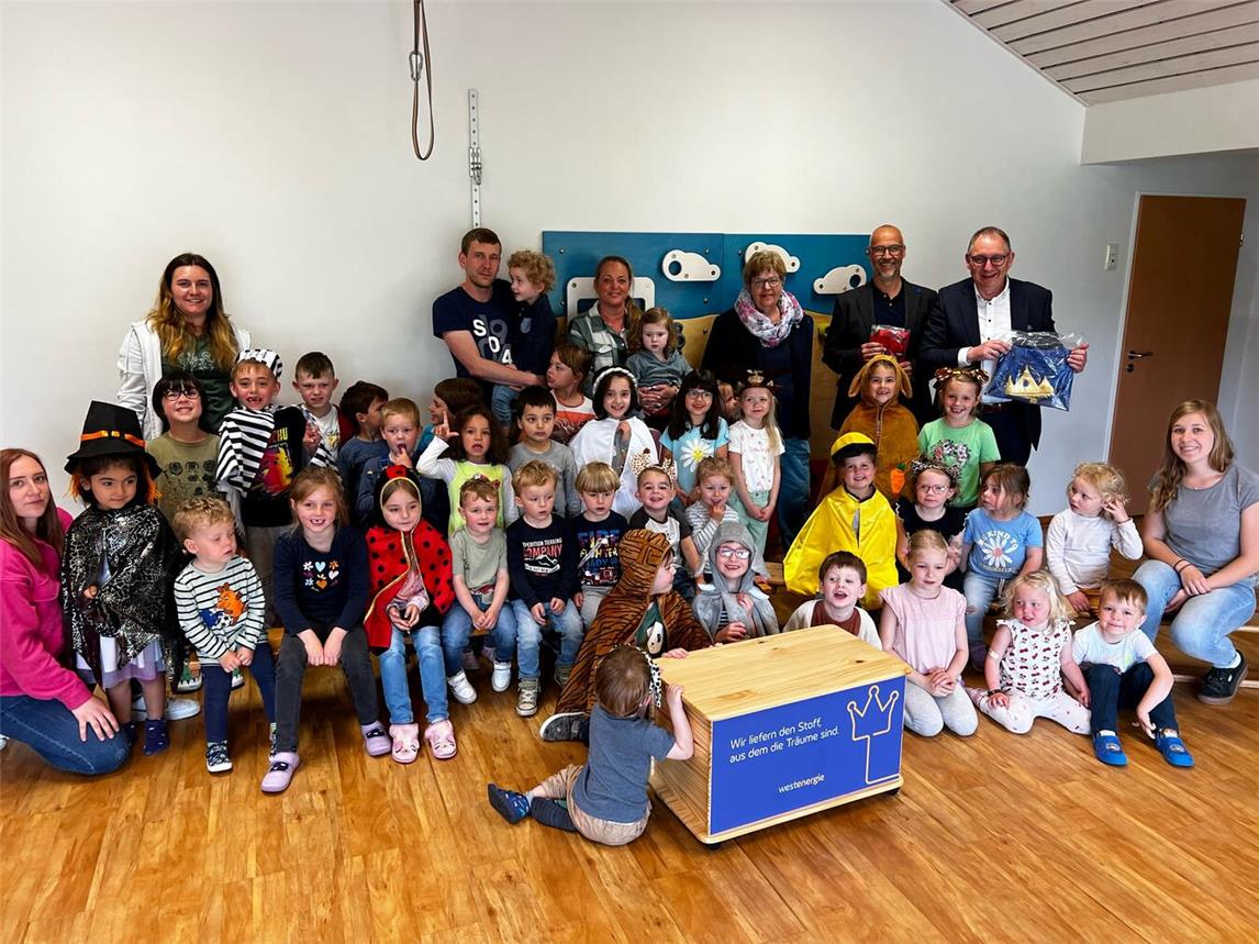 Mit der Theaterkiste der Westenergie wird der Alltag für die Kindergartenkinder im Familienzentrum Regenbogen Haldern ab sofort etwas bunter. Bürgermeister Sebastian Hense (hinten r.) übergab gemeinsam mit Dirk Krämer (hinten 2. v. r.) den Verkleidungsspaß an die Kindergartenkinder. Foto: Stadt Rees