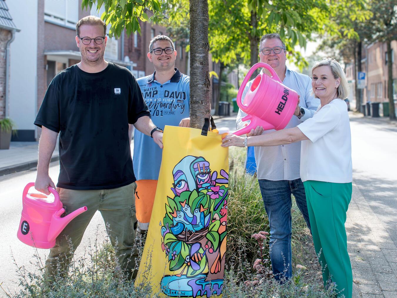 Mit diesen außergewöhnlichen Baumbewässerungssäcken wird der öffentliche Straßenraum zur Kunst-Galerie. Die Gemeinde Weeze verfügt jetzt über 25 Exemplare, v.l.: Bernd Dicks (San Hejmo), Christian Joppe (Bauhof Gemeinde Weeze), Georg Koenen, Bettina Donges (E wie einfach). NN-Foto: Gerhard Seybert