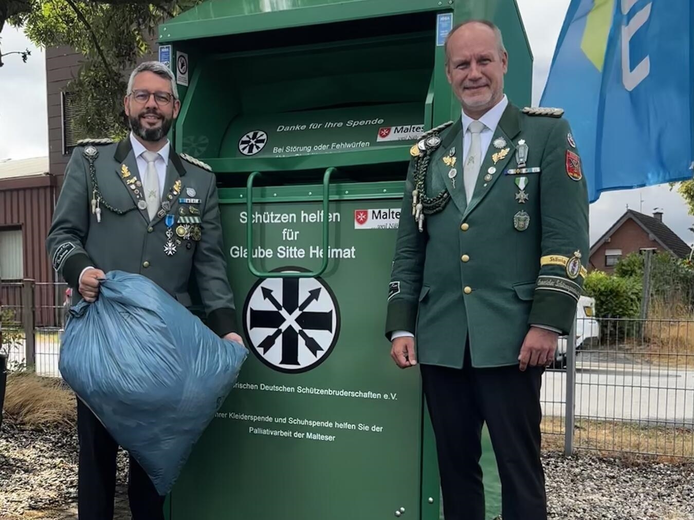 "René Bolk und Sören Fork vor grünem Altkleidercontainer in Elten, Bruderrat Bezirksverband"