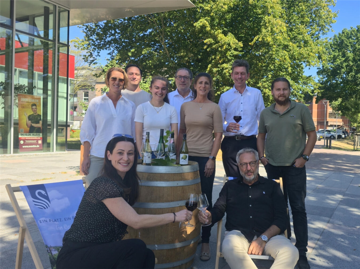 Prost beim After Work Weinfest: Menschen sitzen gesellig zusammen und heben Weingläser an.
