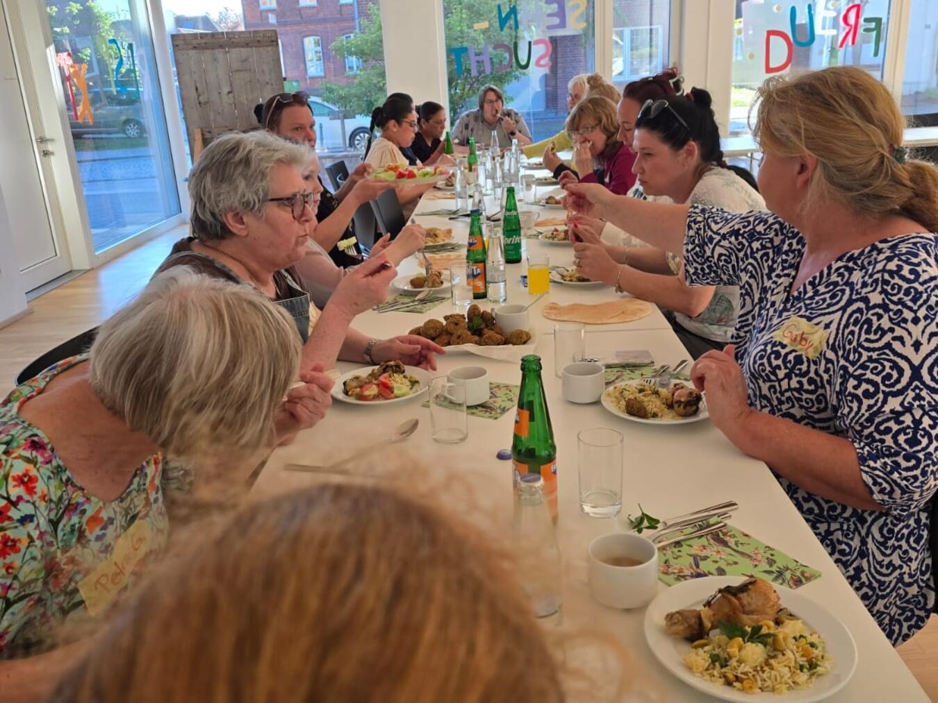 "Gruppe genießt gemeinsames Essen nach Kochsession in Sonsbeck, Gemeinschaftsgefühl, kulinarisches Erlebnis"