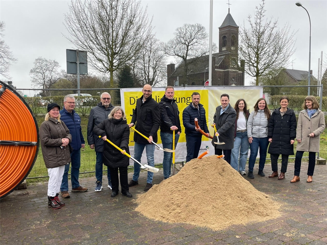 Nadine Bogedain, Bürgermeisterin der Gemeinde Sonsbeck, Ludger Staymann, Bürgermeister der Gemeinde Alpen, Lukas Hähnel, Leiter der Entwicklungsagentur Wirtschaft des Kreises Wesel (EAW; v.l.), sowie die ausbauende Firma MUENET und Vertreter der Fördermittelgeber von Bund und Land und die Breitbandbeauftragten aus den Kommunen freuen sich über den Spatenstich. Foto: Kreis Wesel