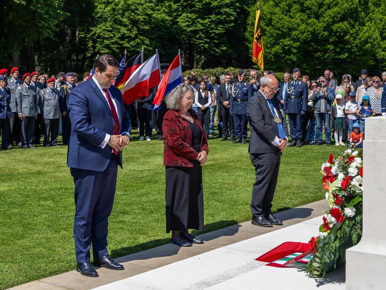Nathanael Liminski (Minister für Bundes- und Europaangelegenheiten, Internationales sowie Medien des Landes Nordrhein-Westfalen und Chef der Staatskanzlei), Dr. Berta Heins (stellvertretende Bürgermeisterin der Gemeinde Kranenburg) und Wolfgang Gebing (Bürgermeister der Stadt Kleve) gedenken der Gefallenen auf dem Britischen Ehrenfriedhof (v.l.). Foto: Stadt Kleve