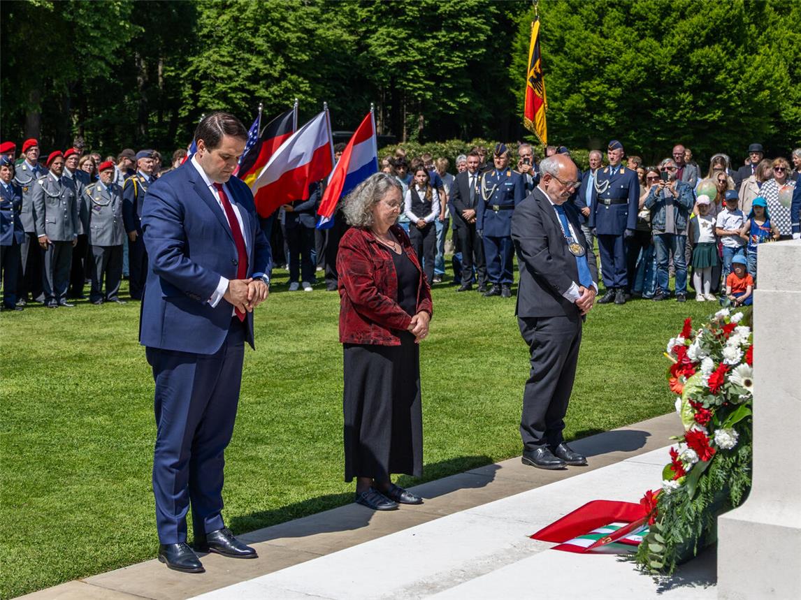 Nathanael Liminski (Minister für Bundes- und Europaangelegenheiten, Internationales sowie Medien des Landes Nordrhein-Westfalen und Chef der Staatskanzlei), Dr. Berta Heins (stellvertretende Bürgermeisterin der Gemeinde Kranenburg) und Wolfgang Gebing (Bürgermeister der Stadt Kleve) gedenken der Gefallenen auf dem Britischen Ehrenfriedhof (v.l.). Foto: Stadt Kleve