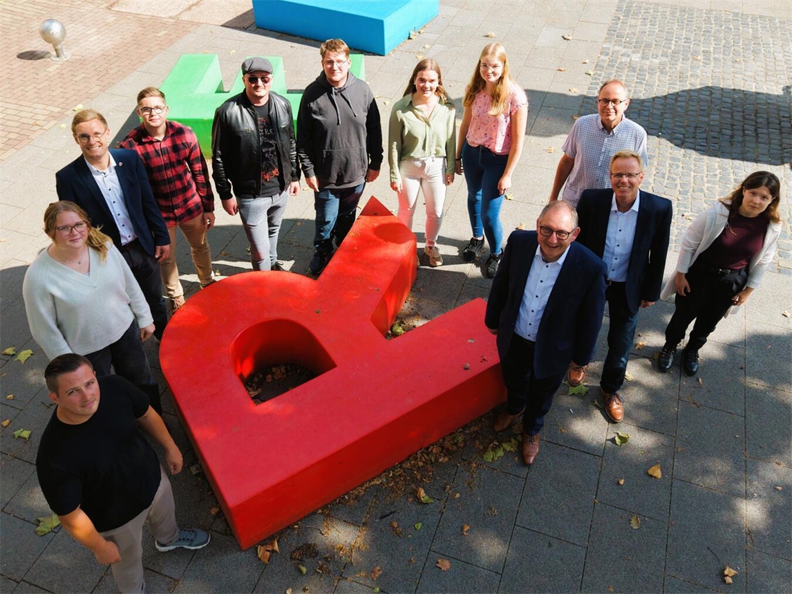 "Gruppenfoto neuer Auszubildender und Absolventen der Stadt Rees bei festlicher Feier"