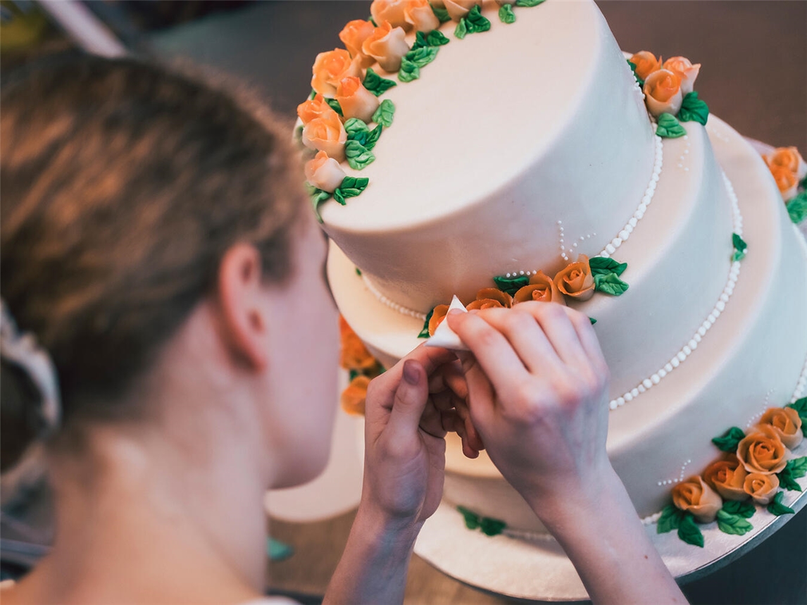 Konditorlehrling dekoriert Torte in Bäckerei, betont kreative Seiten der Ausbildung, Rat der NGG für Jugendliche im Kreis Kleve