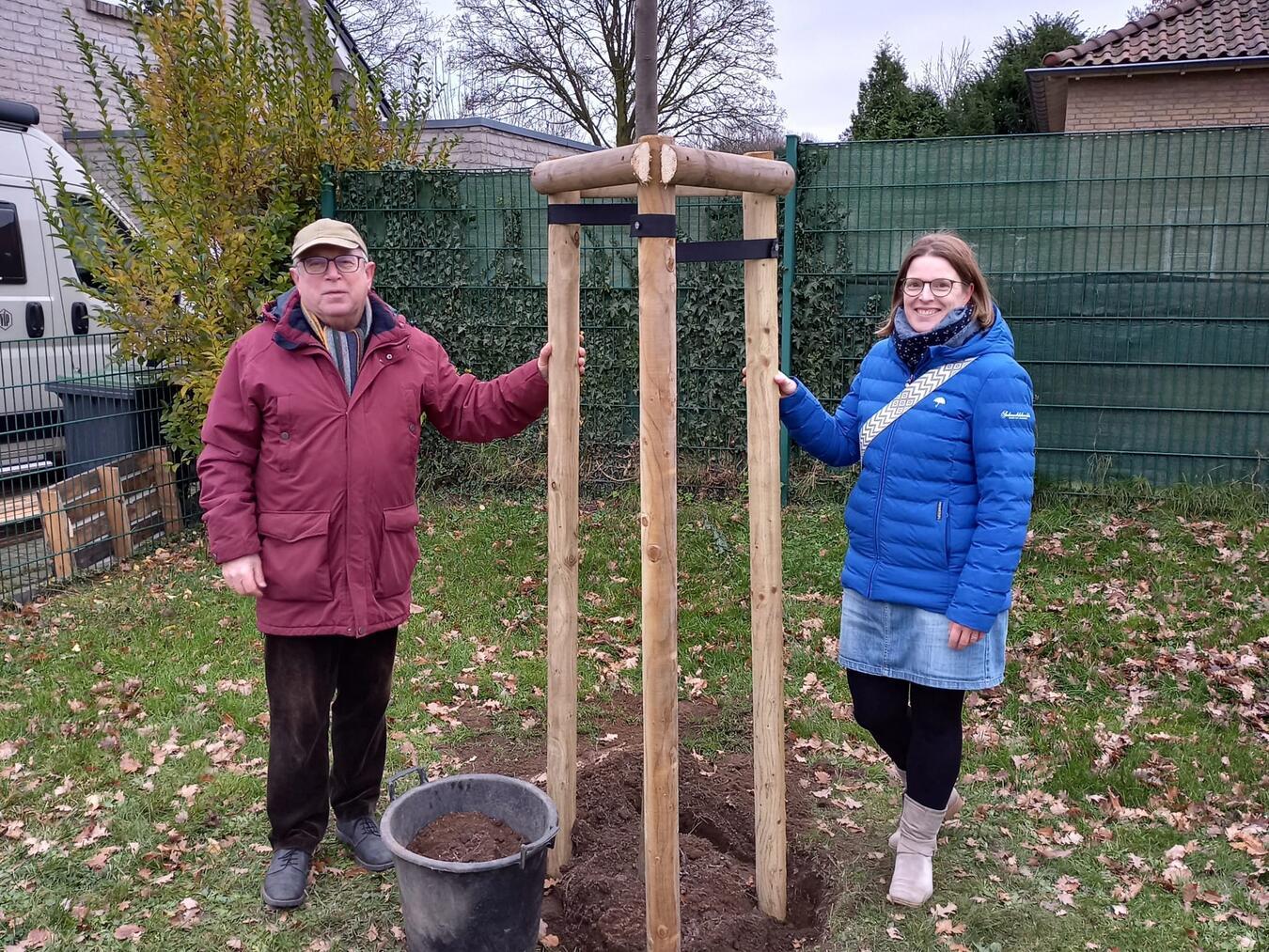 Nicht nur optisch ein Gewinn, sondern auch ein Beitrag für die Umwelt: Ortsvorsteher Albert Jansen und Yvonne van Dillen, Kassiererin des Verschönerungsvereins Elten, mit dem neuen Baum. Foto: privat