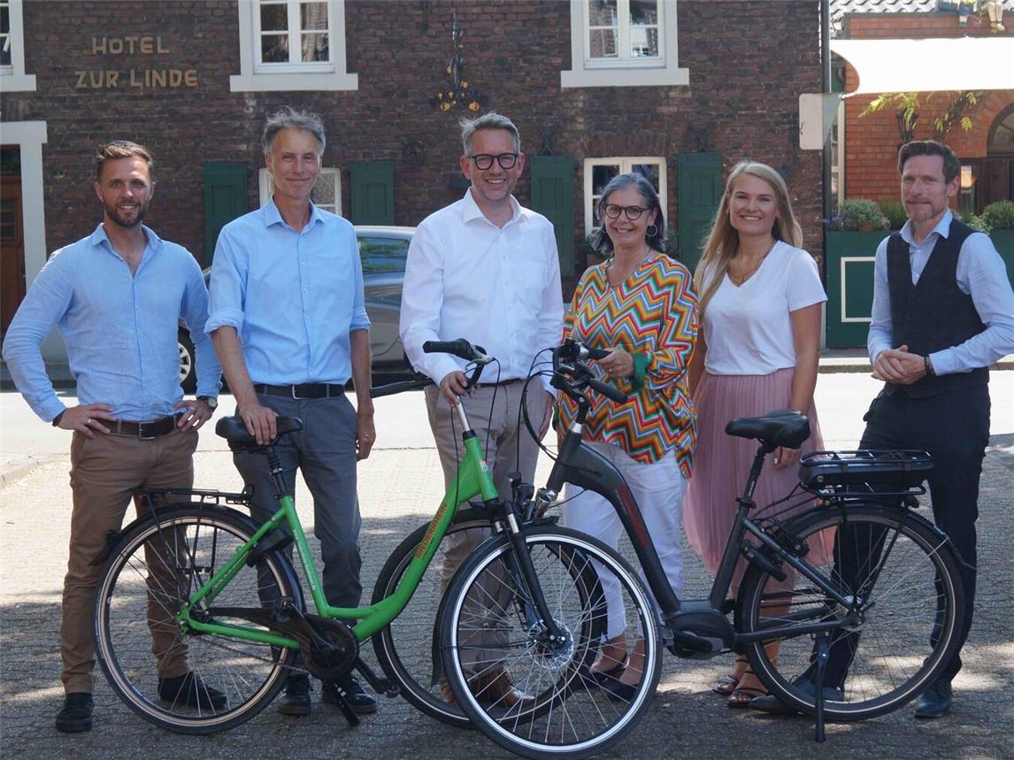 NT-Geschäftsführerin Martina Baumgärtner (3.v.r.) und ihre Kollegin Kathrin Peters (bei NT für das Thema NiederrheinRad zuständig) freuen sich über die große Zustimmung für das NiederrheinRad. Zum Austausch am Wellings Romantik Hotel zur Linde in Moers-Repelen waren Lukas Hähnel (EAW), Jens Heidenreich (Wirtschaftsförderung Moers), Landrat Ingo Brohl sowie Jan Gebühr (von den Welling-Hotels) gekommen (v.l.).Foto: NT