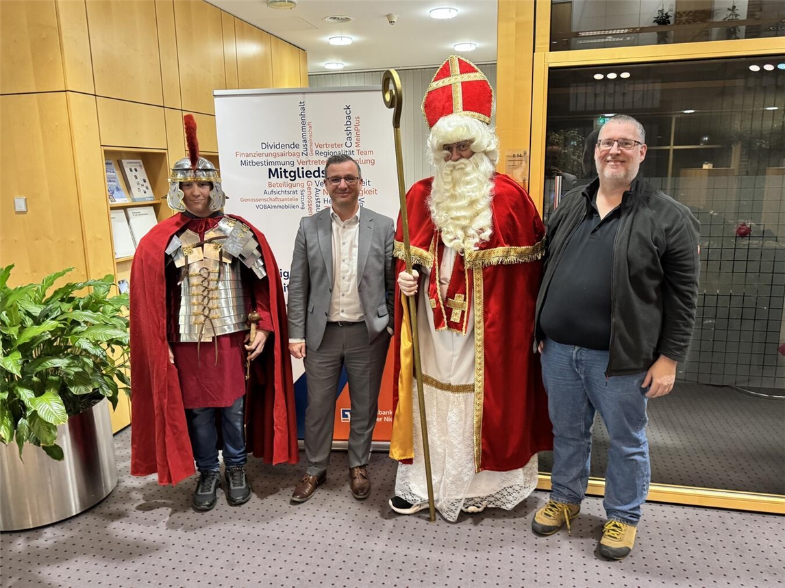 Oeconomia-Vorsitzender Andreas Theunissen (rechts) und seine Mitstreiter bedankten sich bei Volksbank-Geschäftsstellenleiter Mario Lüfkens für die Unterstützung bei der Anschaffung neuer Kostüme für Nikolaus und St. Martin. Foto: Volksbank
