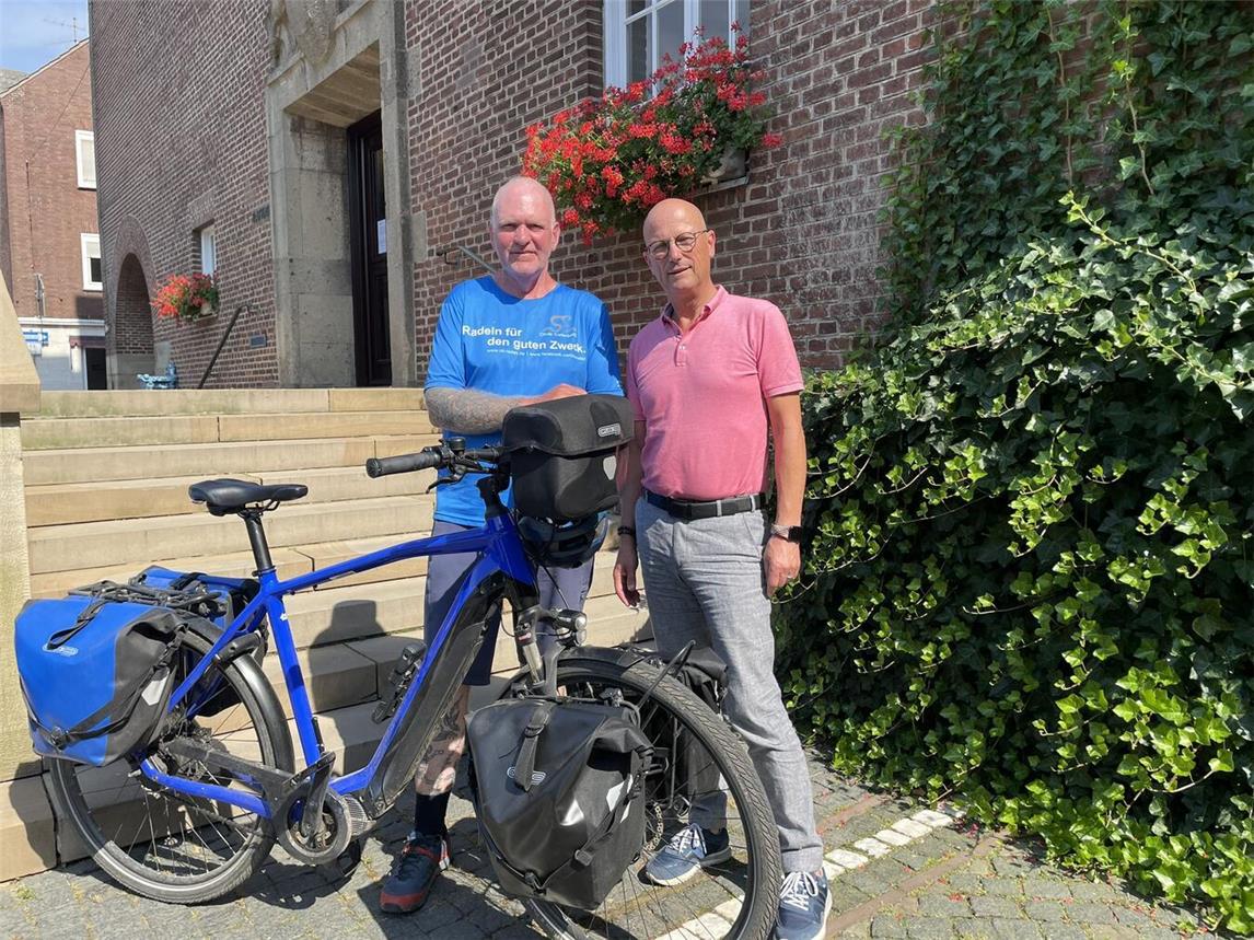 „Oli radelt“ vor dem Rathaus: Bürgermeister Peter Hinze mit Oli Trelenberg. Foto: Stadt Emmerich