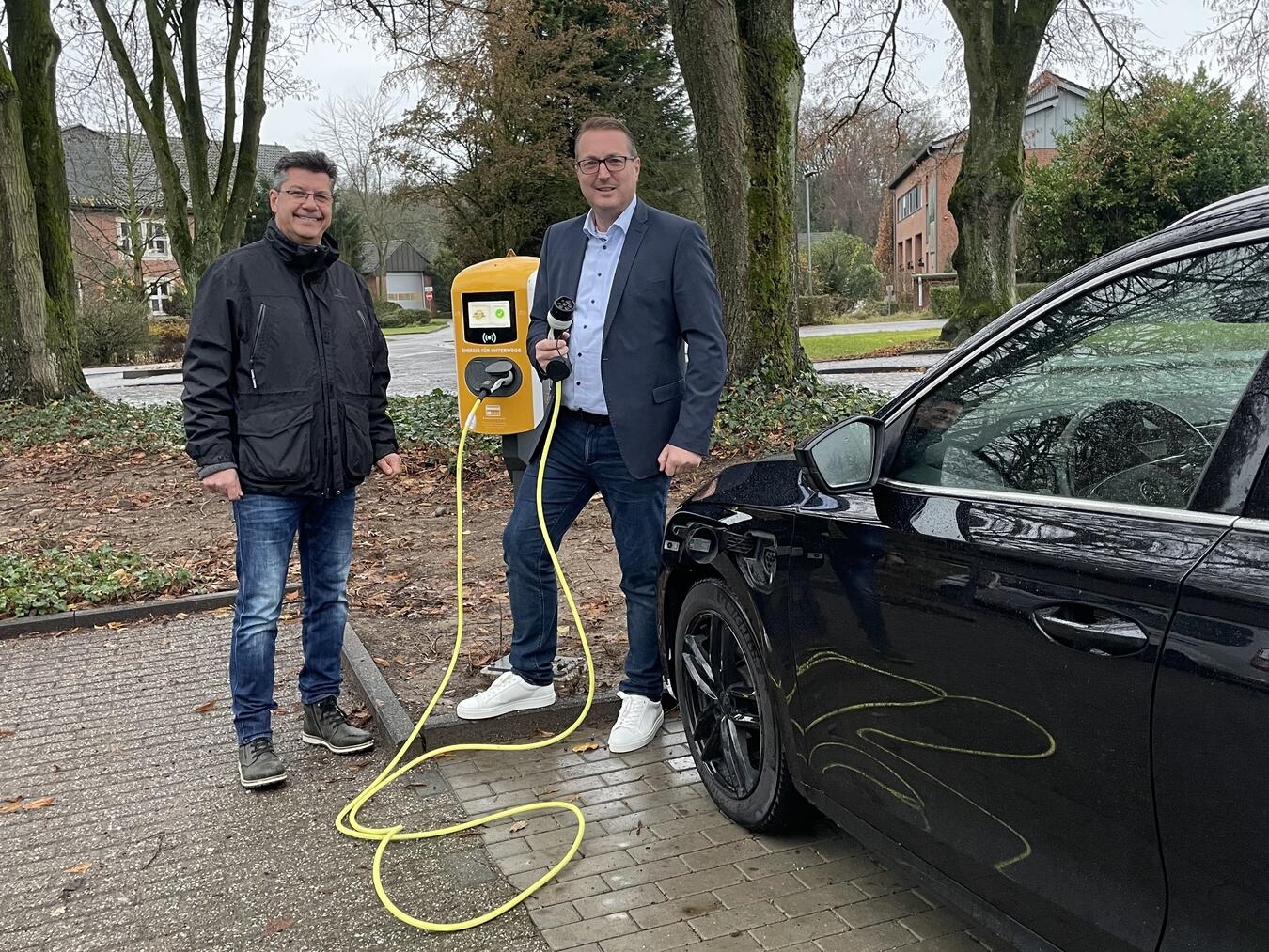 Oliver Schönke (Technischer Leiter, l.) und Marco Plum (Geschäftsführer, r.) mit einer neuen Ladesäule. Foto: Sankt Josef-Hospital