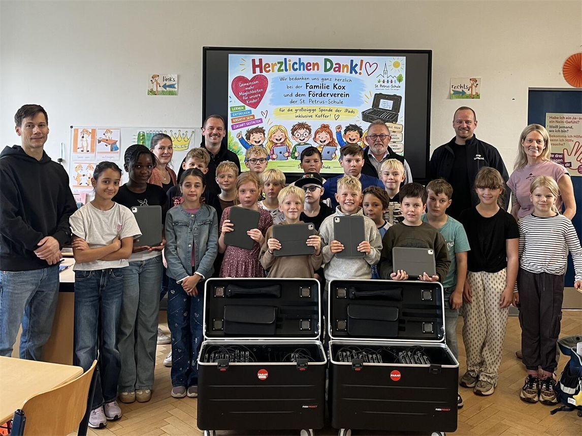Patrick, Peter und Philipp Kox (Edeka Kox), Anja Bandur (Förderverein der St. Petrus-Schule), Susanne Karpe (Schulleitung), Martin Eichhorn (Lehrkraft) sowie die Schüler der vierten Klasse bei der Übergabe der neuen Geräte. Foto: privat