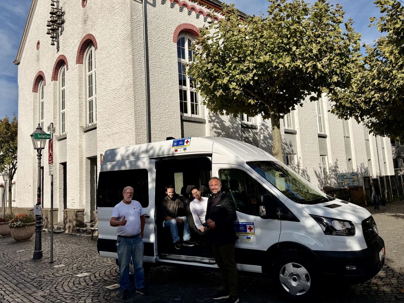 Peter Hilbig, Vorsitzender der Ukrainehilfe Niederrhein e.V. , Stefan Roeloffs, Fachbereichsleiter Wirtschaftsförderung und Grundstücksmanagement der Stadt Xanten, Anika Hartwich, Mitarbeiterin Liegenschaften der Stadt Xanten, und Xantens Bürgermeister Rafael Zur (v.l.) am neuen Schulbus für die Ukraine. Foto: privat