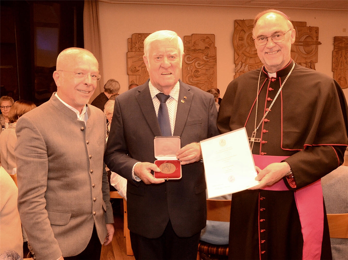 Pfarrer Dietmar Heshe, Heinrich Henrichs und Regionalbischof Rolf Lohmann (v. l.) bei der Verleihung der Paulusplakette im Gemeindesaal in Ginderich. Foto: Bischöfliche Pressestelle/Jürgen Kappel