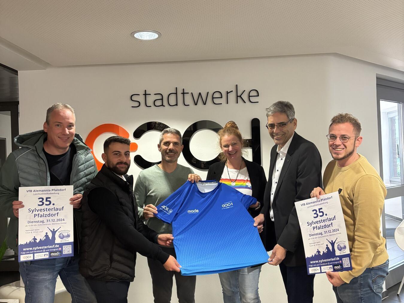 Präsentieren das Sylvesterlauf-Funktionsshirt (v.l.): Ralph Sluiters (Orga-Team), Emre Onat (AOK Rheinland/Hamburg, Fachberater Marketing), Andreas de Matteis (macle GmbH), Kristina Derks (Vertriebs- und Marketingleitung Stadtwerke Goch), Burkhard Simons (Volksbank an der Niers, Geschäftsstellenleiter Pfalzdorf) und Tim Verhoeven (Orga-Team).Foto: Billie-Marie Maus