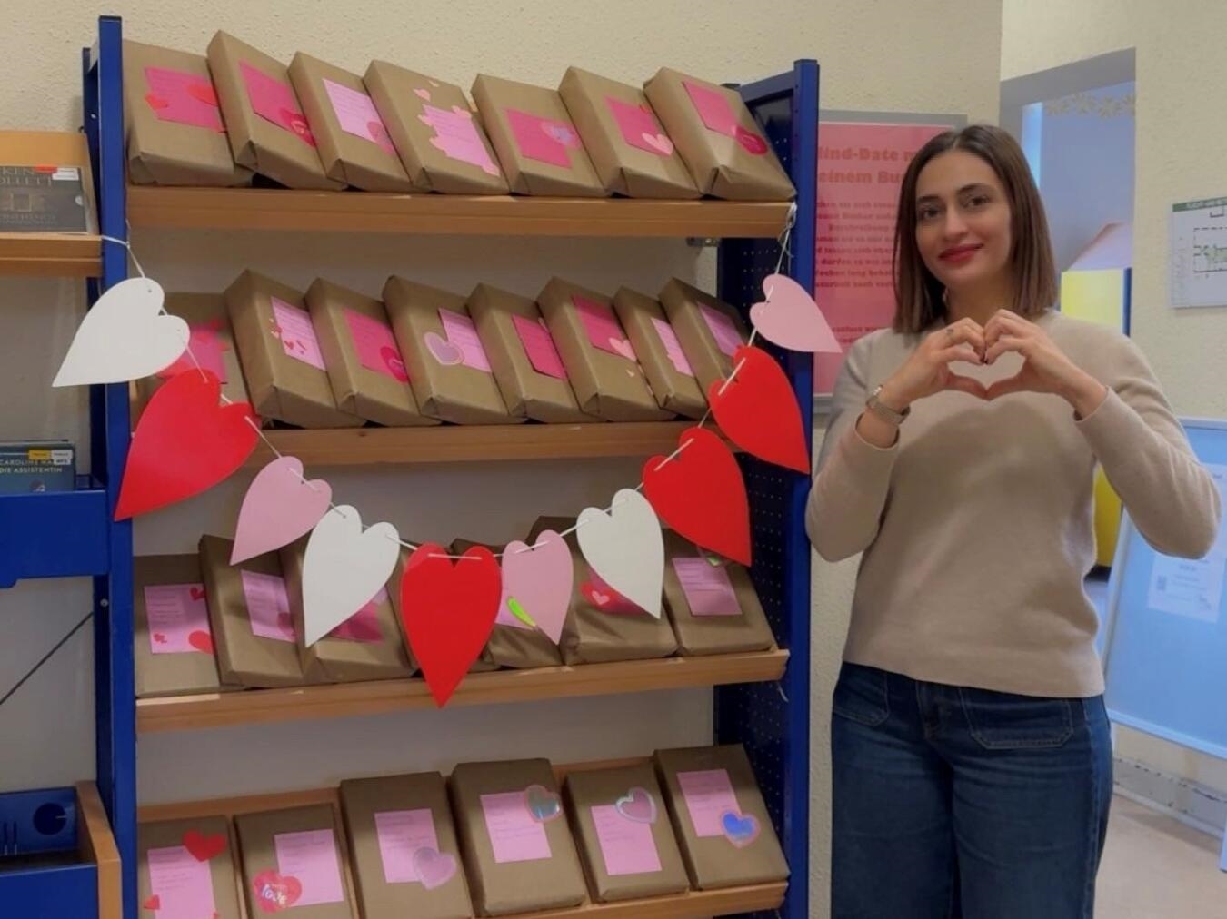 Praktikantin Zehra Onalan, die das Büchereiteam bei der Blind-Date-Aktion unterstützt, präsentiert die verpackten Bücher. Foto: Stadt Rees