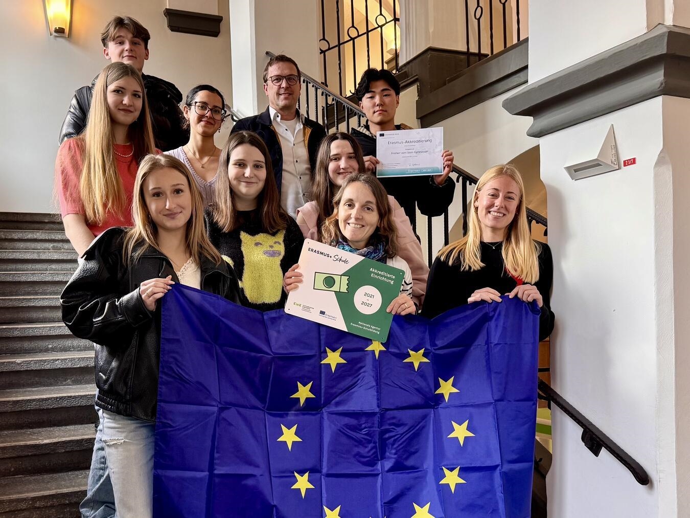 Projekt-Koordinatorin Steffi Moerkerk (vorne M.) mit der Plakette, Schulleiter Timo Bleisteiner (hinten M.) und Schüler, die am Italienaustausch der Schule teilgenommen haben. Foto: privat