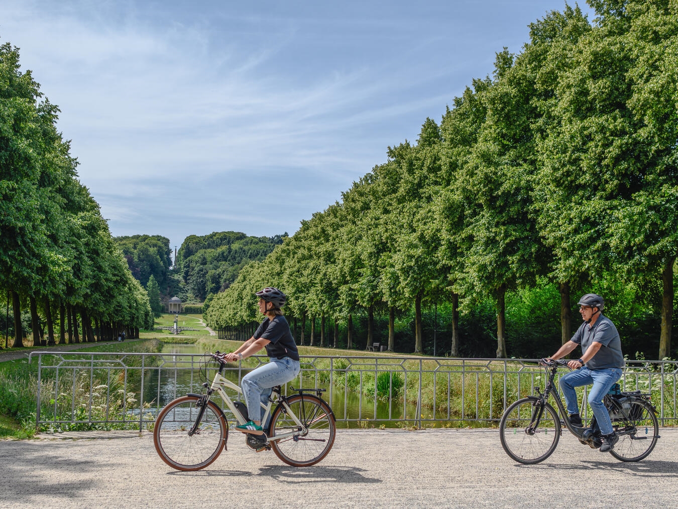 "Radfahrer fährt durch grüne Gartenanlagen bei Sonnenschein, Erholung in der Natur"