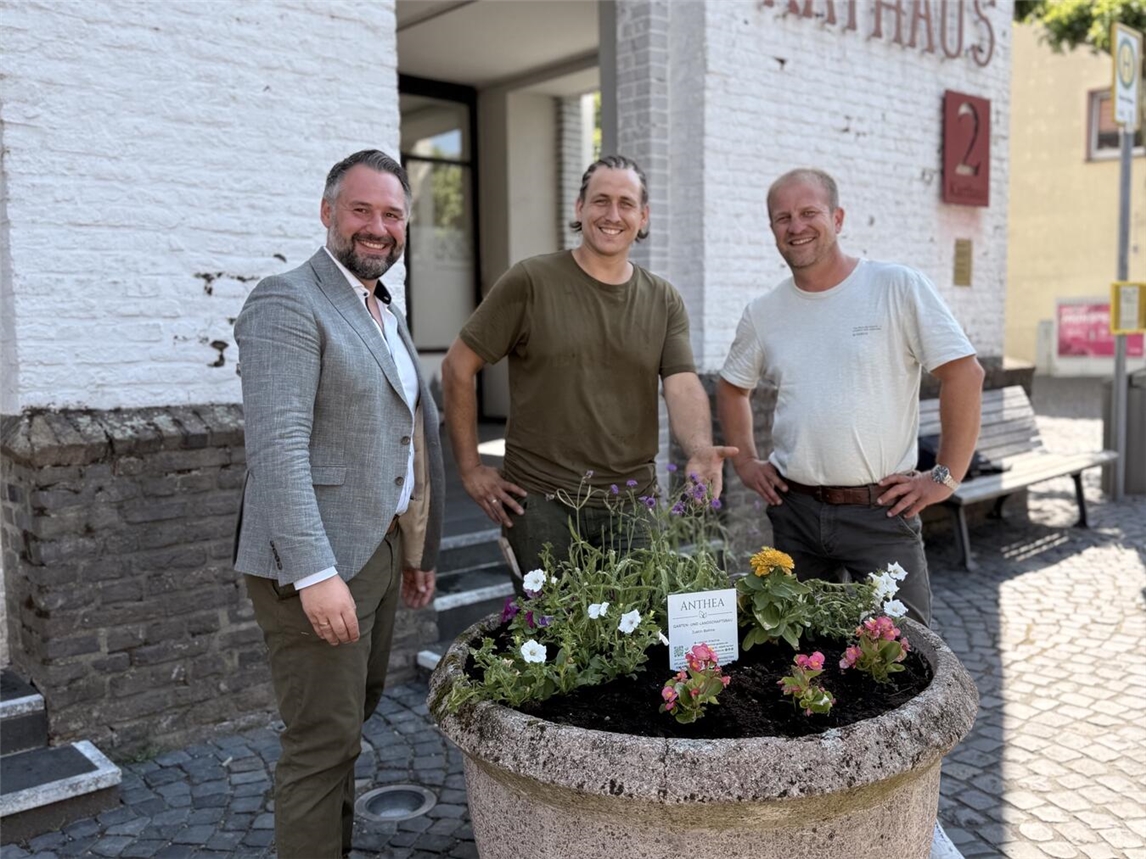 Rafael Zur (Bürgermeister der Stadt Xanten), Justin Bohne (Inhaber ANTHEA Garten- und Landschaftsbau) und Christian Schmitz (DBX; v.l.) vor dem Xantener Rathaus. Foto: Stadt Xanten