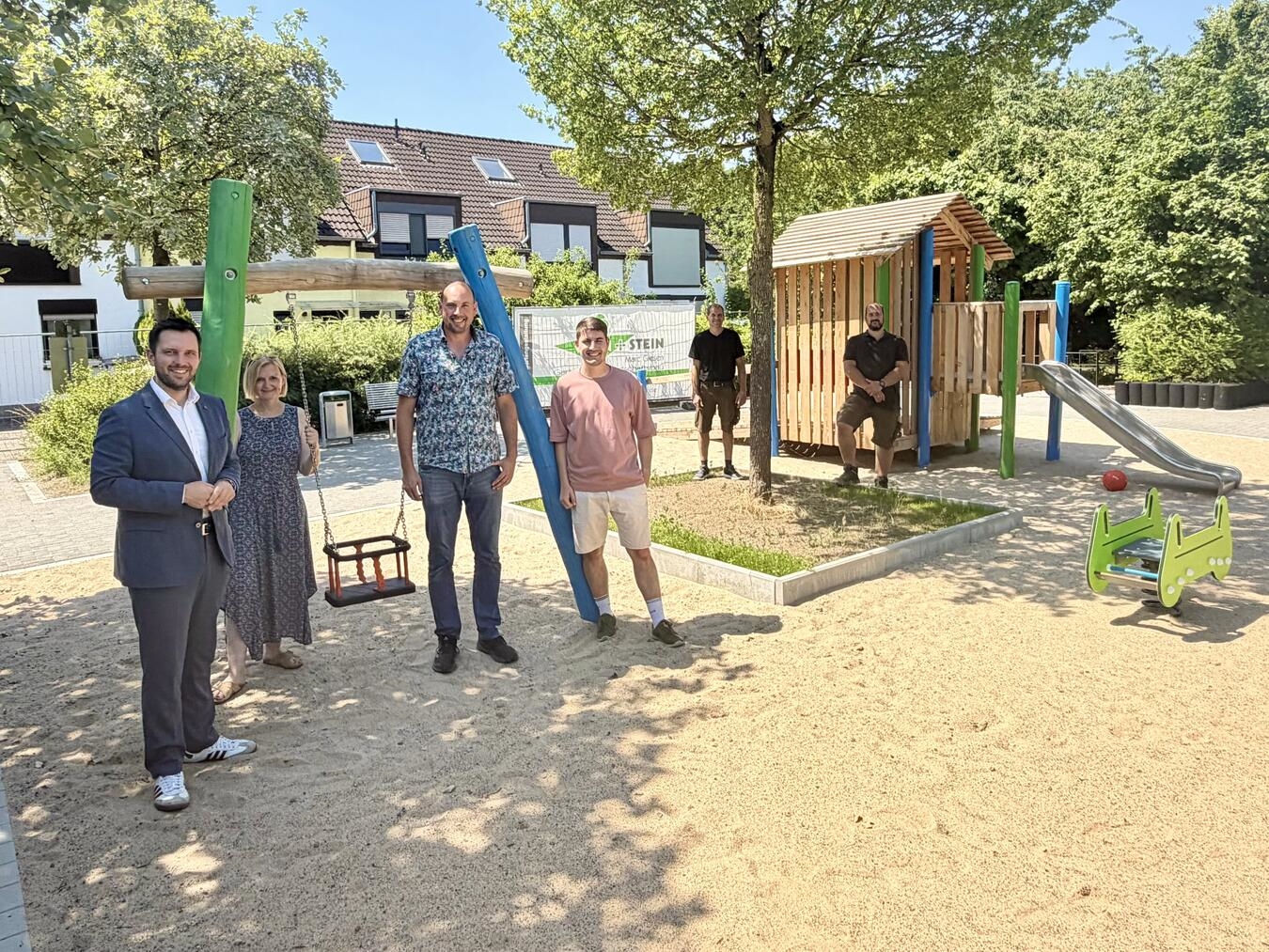 Rheinbergs Bürgermeister Philipp Richter und Babette Heimes (Sachgebietsleiterin Fachbereich Jugendpflege), freuen sich sehr, dass der Spielplatz Memeler Ring 2 so gut gelungen ist und bedankten sich bei Markus Kern und Simon Mosters vom Fachbereich Tiefbau und Grünflächen, sowie bei Jan Blum und Geschäftsführer Marc Giesen vom ausführenden Garten- und Landschaftsbaubetrieb Grün+Stein aus Alpen. Foto: Stadt Rheinberg