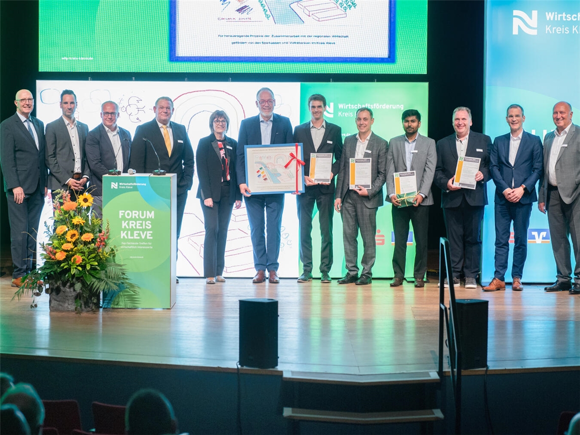 Rückblick auf die Hochschul-Preis-Verleihung 2025: Die glücklichen Preisträger – die Ipsen International GmbH und die Fakultät Technologie und Bionik der Hochschule Rhein-Waal – gemeinsam mit den Juroren auf der Bühne der Klever Stadthalle. Foto: mvo