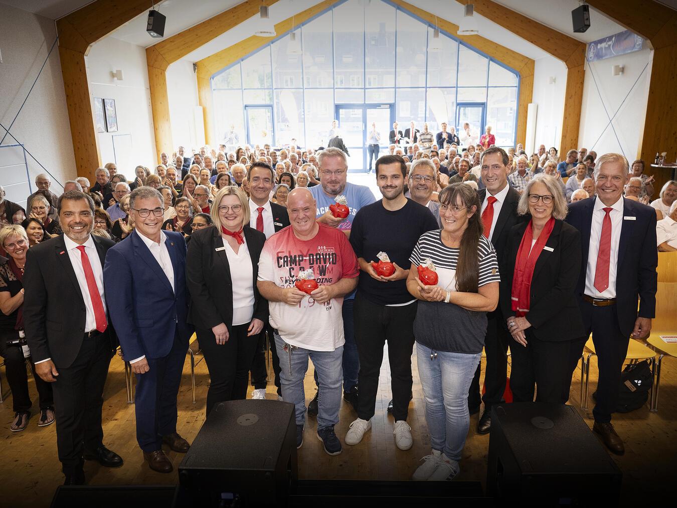 Rund 180 Gäste des Ehrenamtsforums erlebten in der Aula des Amplonius Gymnasiums interessante Interviews mit Ehrenamtlichen und die Ziehung von vier Extraspenden von je 250 Euro. Giovanni Malaponti und Bürgermeister Dietmar Heyde (1. und 2. v.l.) sowie der stellvertretende Landrat Günter Helbig (5. v. r.) und Sparkassenvorstand Bernd Zibell (ganz rechts) gratulierten den Gewinnern. Foto: Bettina Engel-Albustin