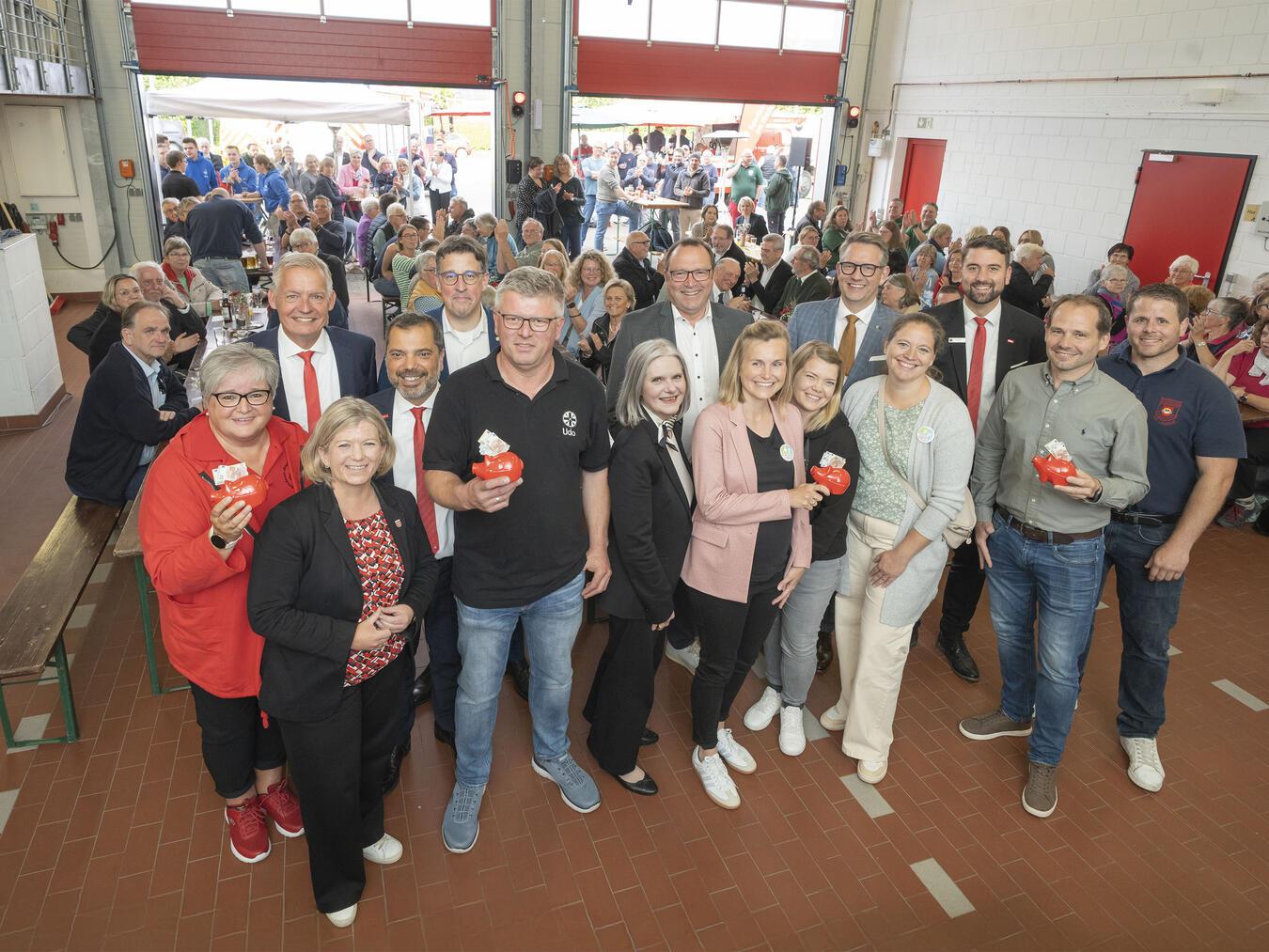 Rund 180 Gäste im Feuerwehrgerätehaus Labbeck erlebten beim Ehrenamtsforum der Sparkasse unterhaltsame Gespräche mit engagierten Ehrenamtlern sowie die Ziehung von viermal 250-Euro-Extraspenden (v.l.): Beate Leiers (Akkordeonorchester), Bernd Zibell (Sparkasse), Bürgermeisterin Nadine Bogedain, Giovanni Malaponti (Sparkasse), René Schneider (MdL), Udo Faltmann (St. Sebastianus Schützen), Claudia van Dyck (Verwaltungsrat), Frank Berger (Beirat), Marie Holland und Katrin Kraft (Dorffamilie), Landrat Ingo Brohl, Anja Grüntjes (Dorffamilie) Markus Hans (Sparkasse), Jürgen Teloo (SV Sonsbeck) und Dominik Brücker (Feuerwehr). Foto: Sparkasse am Niederrhein
