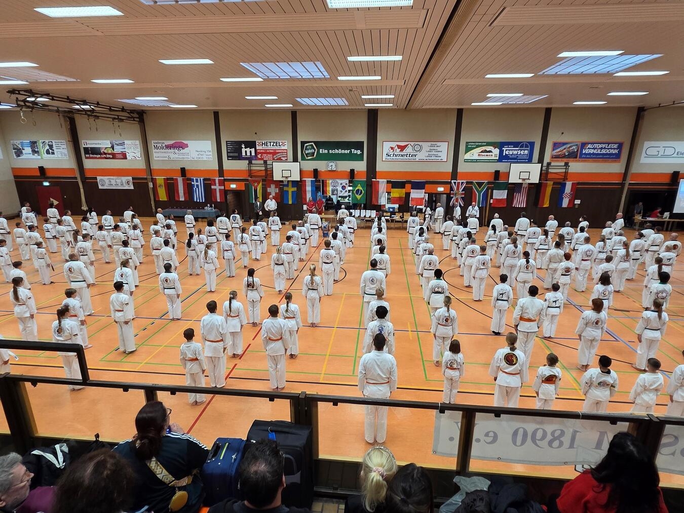 Große Erfolge für Team Issum Rund 200 Kampfsportler stellen sich auf zur offiziellen Eröffnung der Meisterschaft. Begrüßt wurden sie gemeinsam mit den Gästen von Großmeister Klaus Trogemann, Ismus stellvertretenden Bürgermeister Stefan Sablowski und dem 1. Vorsitzenden des TV Issum Rainer Pütz.Foto: Patrik Neuhaus